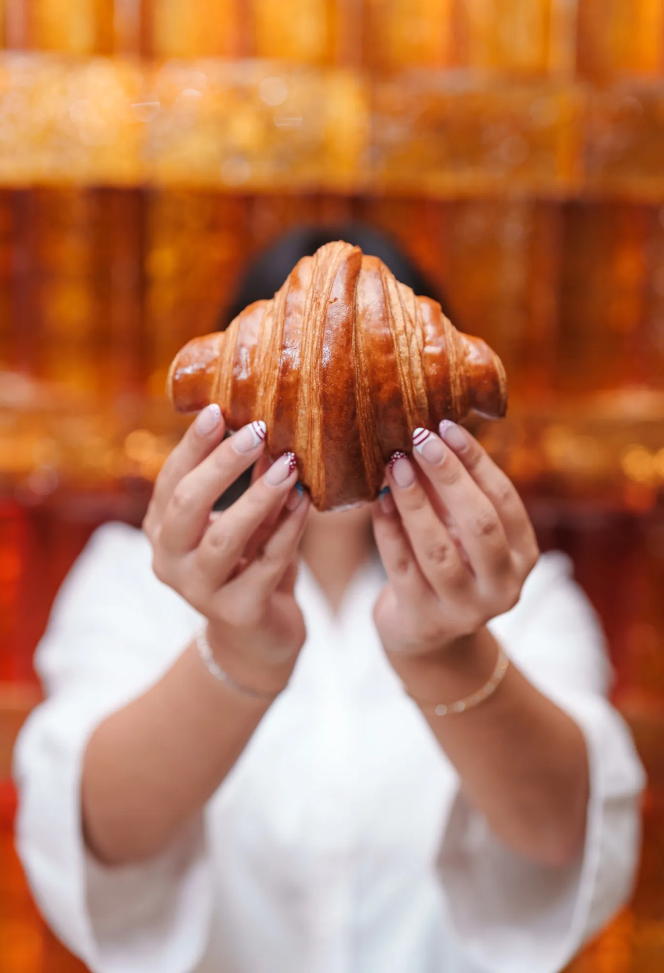 A croissant held up against the glowing amber wall